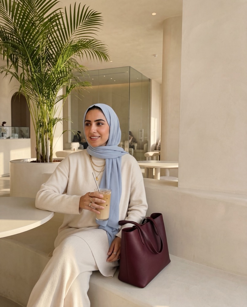 A woman relaxing with an iced coffee in a calm Dubai setting